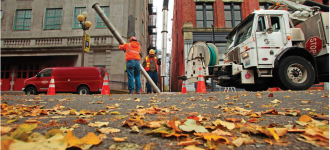 Tevita Vaokakala (left) and Bobby Hayes, both with Seattle Public Utilities, finish cleaning a combined sewer along Main Street in downtown Seattle using a Vac-Con combination sewer cleaning truck.