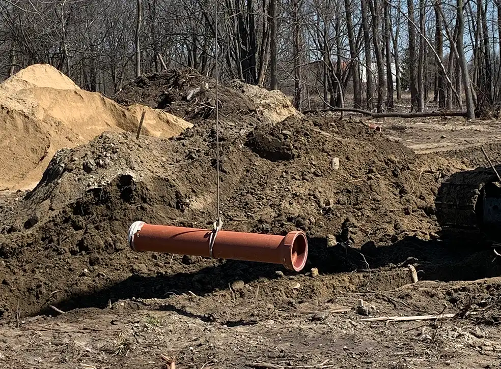 clay pipe being lowered into a trench