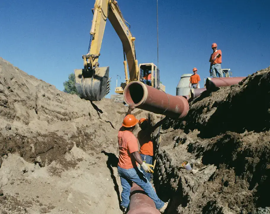 clay pipe being lowered into a trench