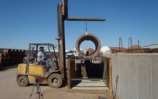 clay pipe being lowered into container